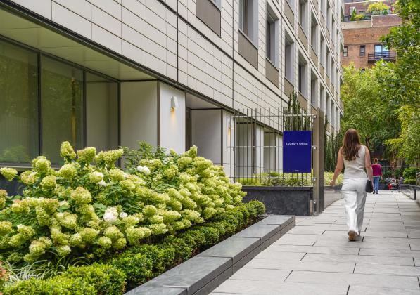 Woman walking in front of the entrance to 211 East 70th St.