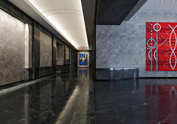 A sleek lobby with artwork on display and a long hallway