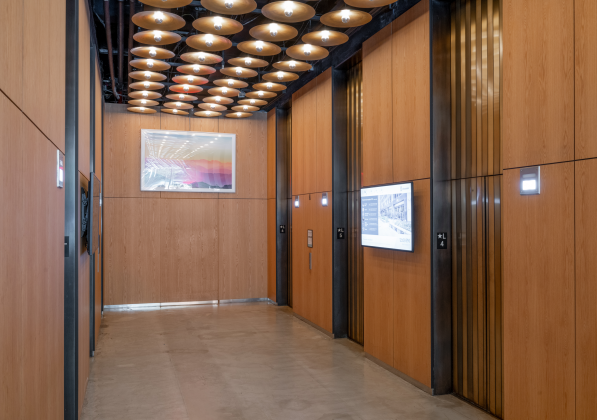 A sleek office hallway with warm overhead lighting 