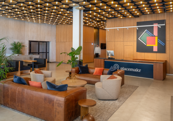 A lobby in an office with a leather couch and a front desk