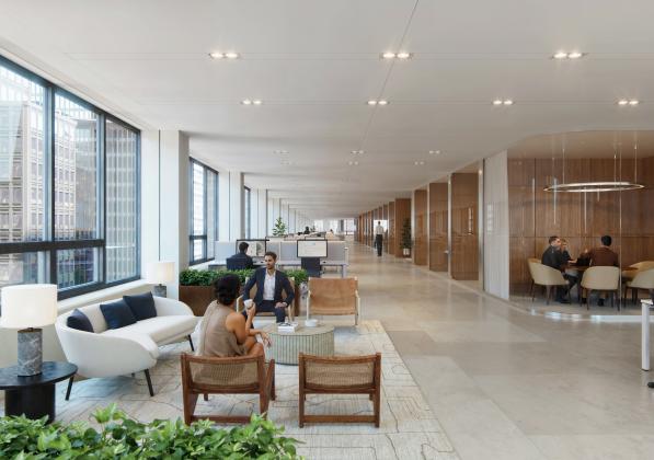 An office space with large windows and workers sitting in meeting rooms or in the reception area