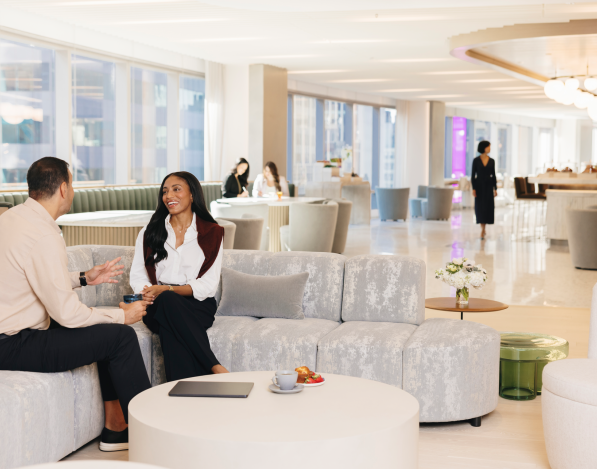 A common area with comfortable seating and large windows in the 3 Time Square office building