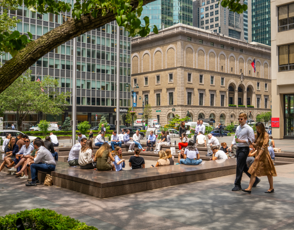 A square outdoor seating area in New York City surrounded by other buildings and trees