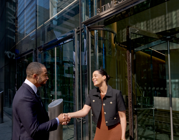 Two professionals shaking hands outside of 3 Times Square