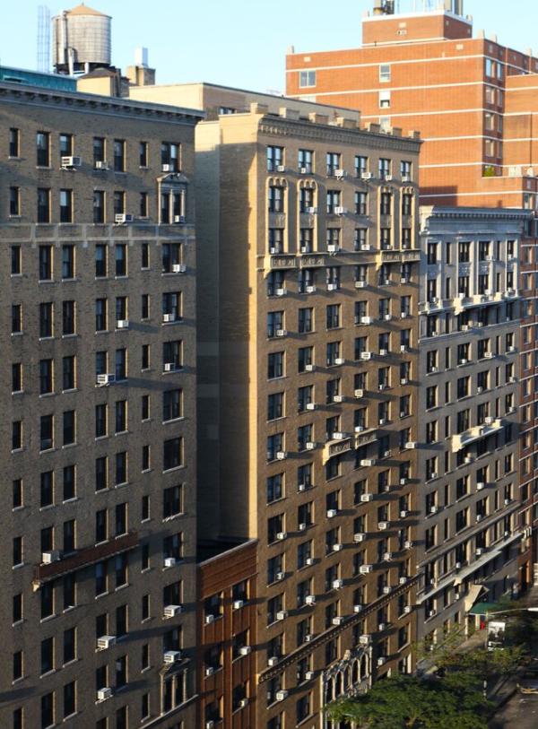 A row of buildings with trees lining the street below