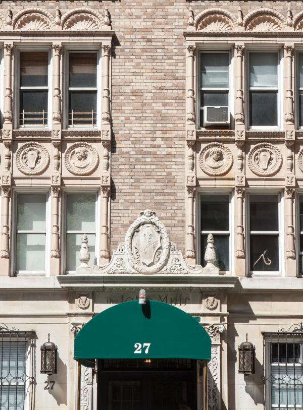 Exterior of a building in New York City with windows and a green awning below
