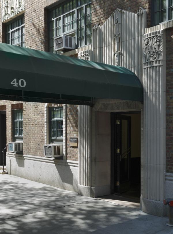 The entrance to a building with a green awning extending out over the sidewalk