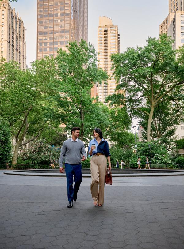 Two professionals walk through Madison Square Park 